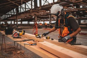 industriarbetare som sågar ved